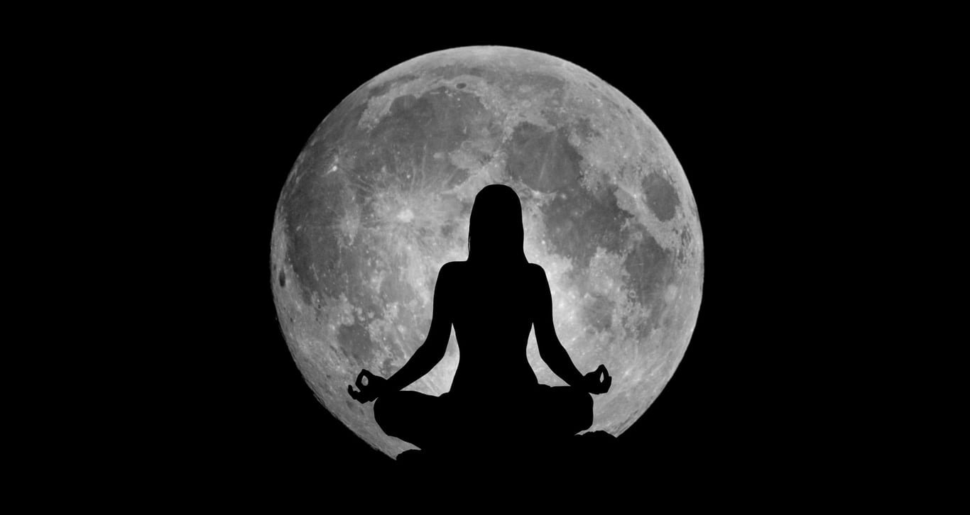 Mujer meditando frente a la luna